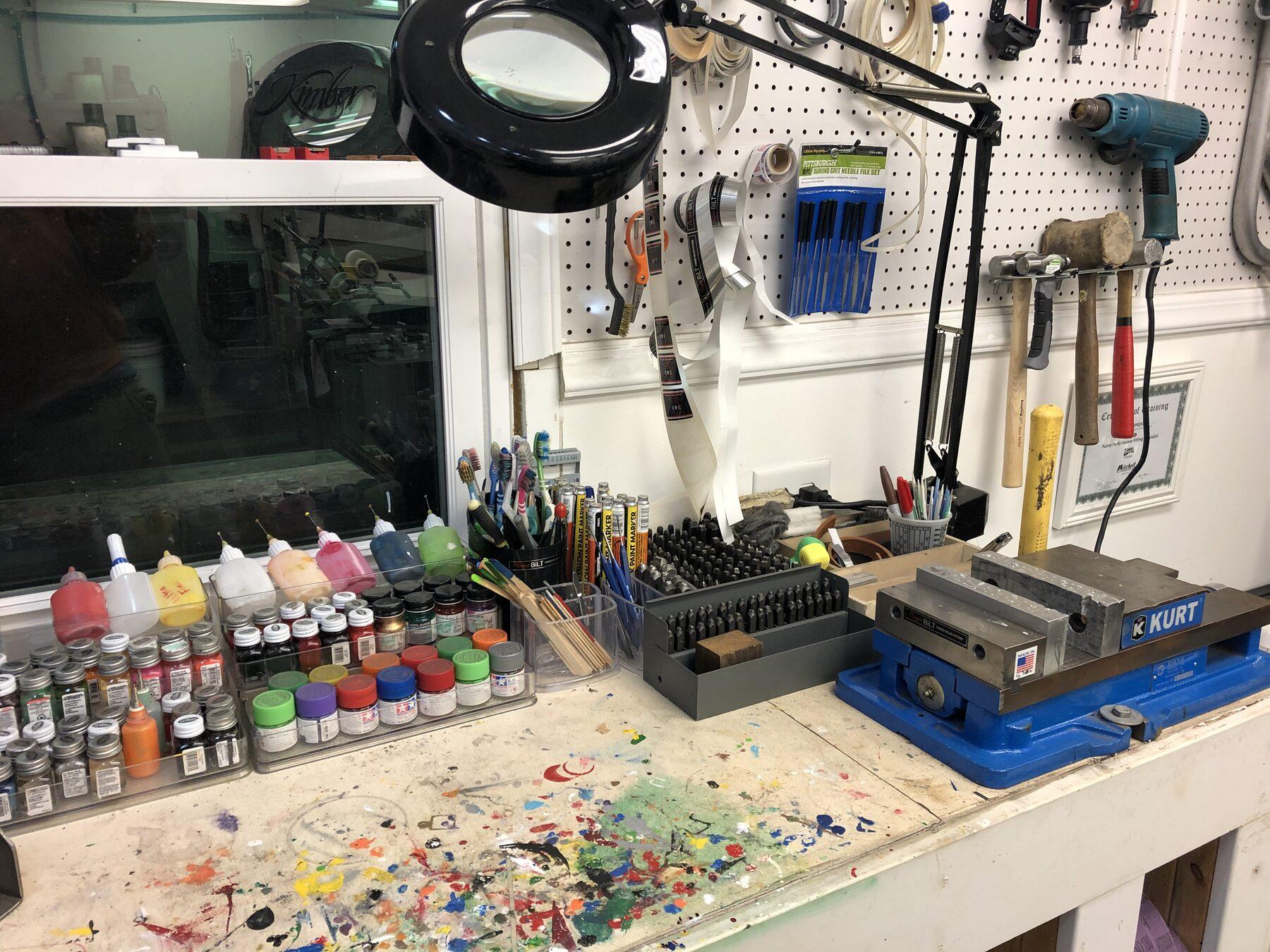 Ken Flanigan's finishing bench in Burton, Ohio — stamps, paint fills, files, and a vise