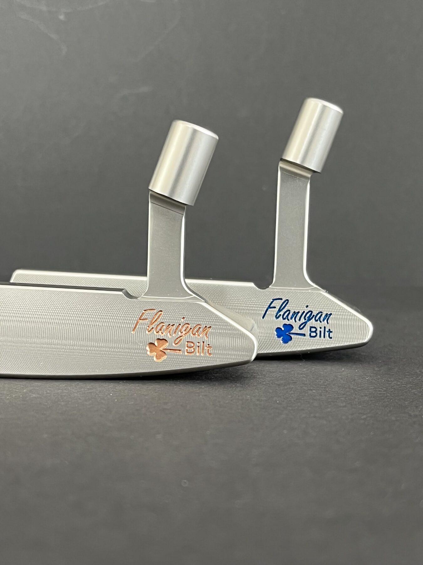 Two Flanigan Bilt FB-series putters milled from soft carbon steel, stamped with the Flanigan Bilt shamrock
